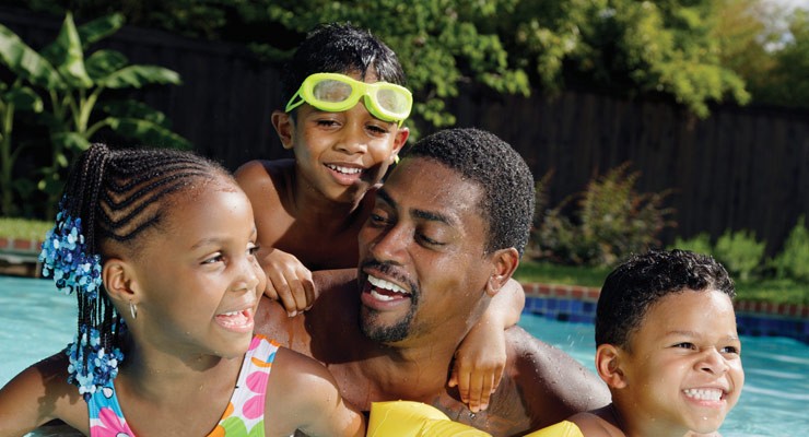 father with children in the pool