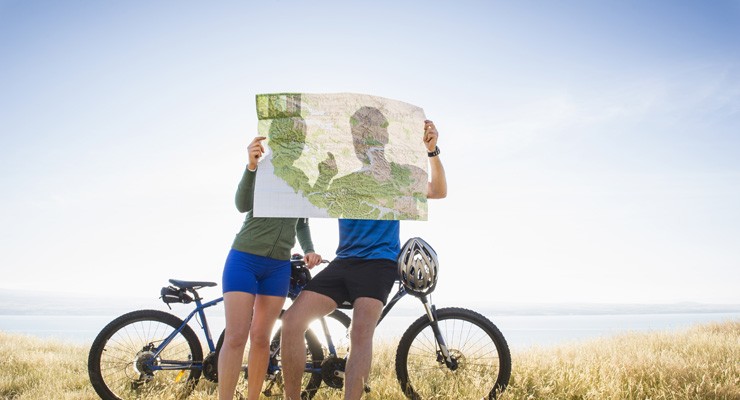 two people with bicycles looking at a map