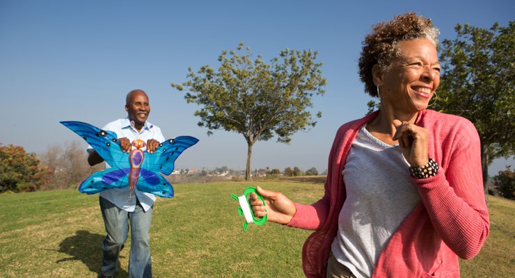 man and woman in field flying a kite