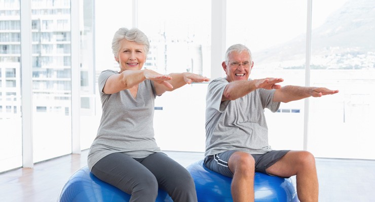 older man and woman sitting on exercise balls