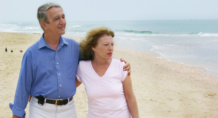 man and woman walking on a beach.
