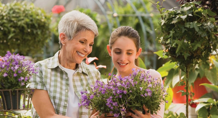 woman and young girl admiring purple flower bouquet