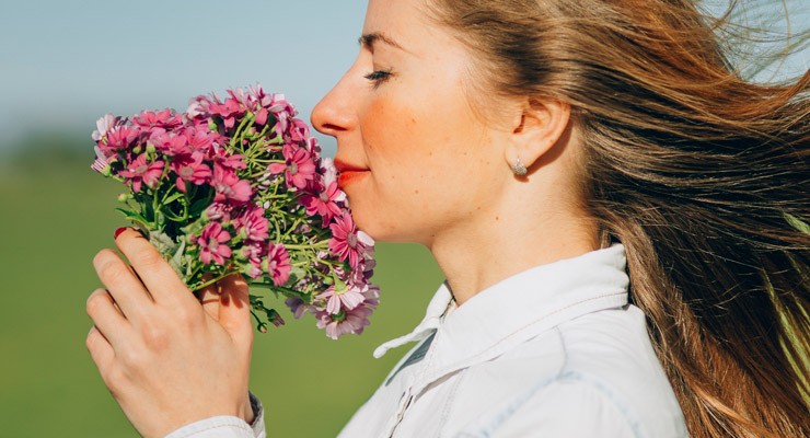 woman smelling pretty bouquet of flowers